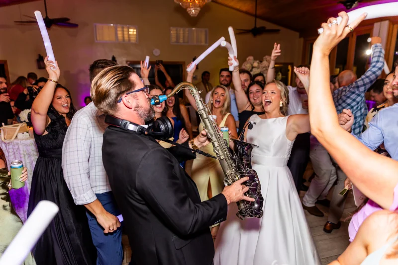 Bride cheering on packed dance floor at Fountain of Youth wedding reception