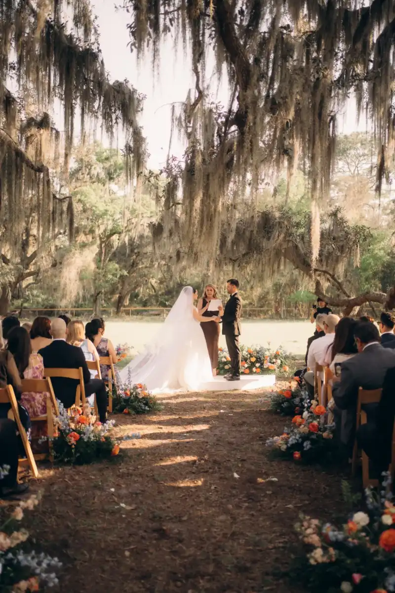 Bride and groom saying vows on a low platform in the open pasture at Golden Creek Ranch