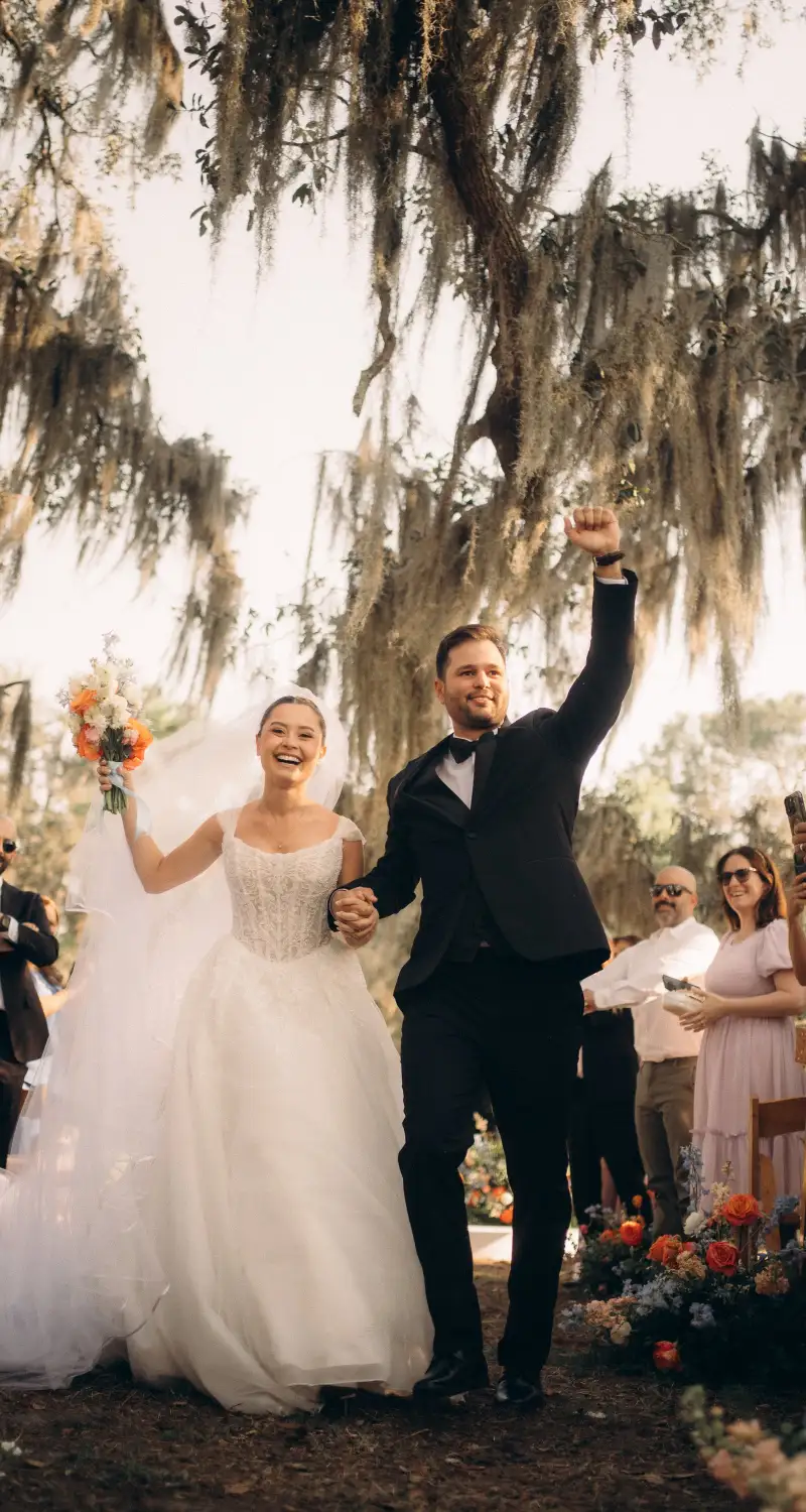 Newlyweds celebrating as they walk back down the aisle under the oaks at Golden Creek Ranch