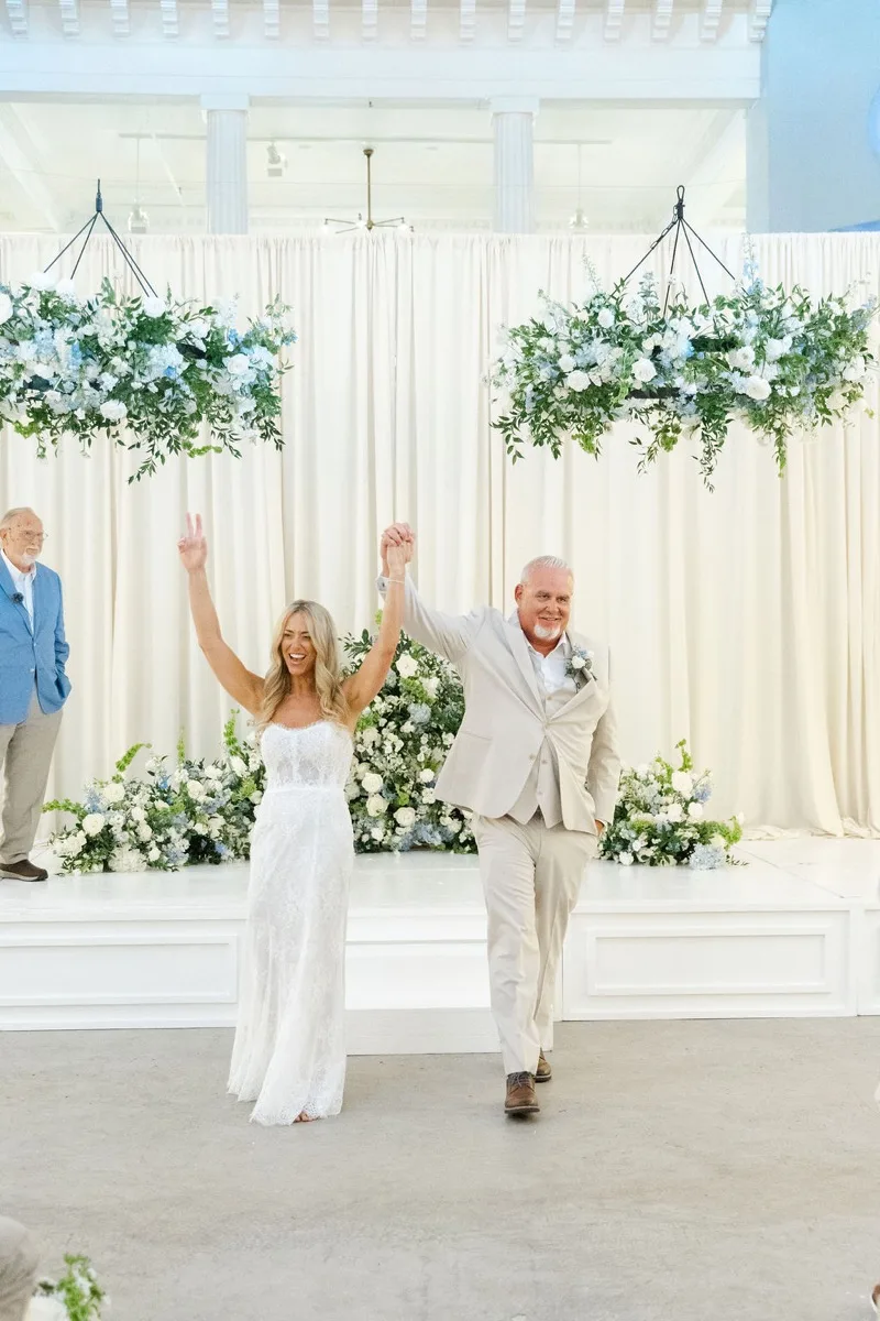 Just-married couple raising hands at Lightner Museum ceremony recessional