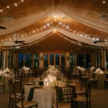 A reception under ceiling draping and warm cafe lights installed by St. Johns Illuminations